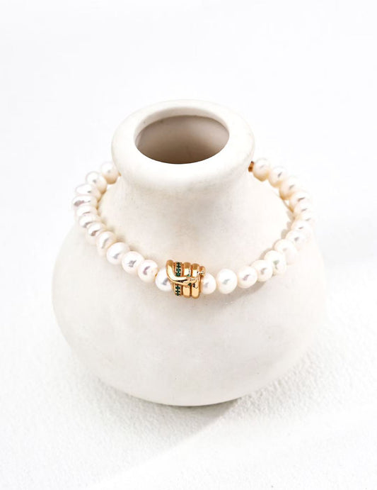 Bracelet Éclats d’Or posé sur vase blanc, perles d’eau douce et anneaux dorés, MeiPerle