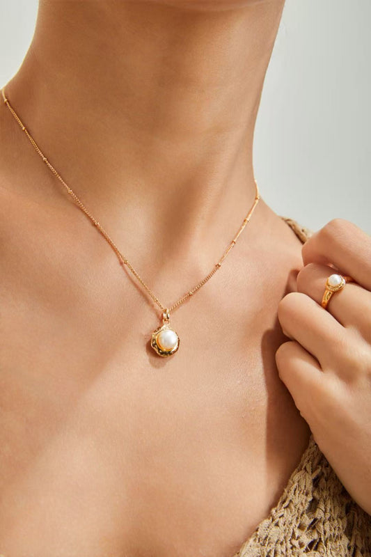 Collier pendentif perle naturelle porté par un modèle, chaîne dorée visible sur le cou