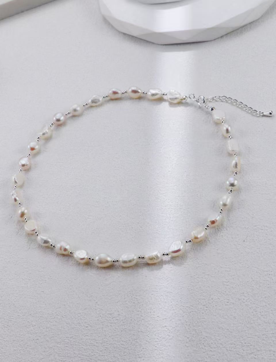 Collier de perles baroques avec fermoir mousqueton argenté sur fond gris