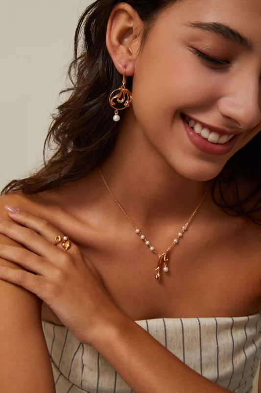 Femme portant un collier en perles naturelles avec pendentif floral doré signé MeiPerle.