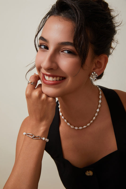 Femme portant le collier en perles baroques et détails argentés