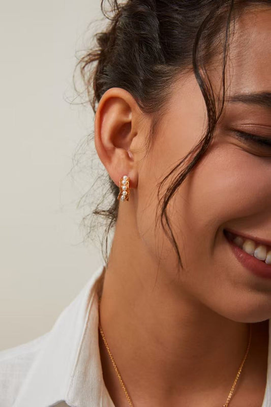 Femme portant les boucles d’oreilles Vagues d’Or en perles naturelles dorées MeiPerle