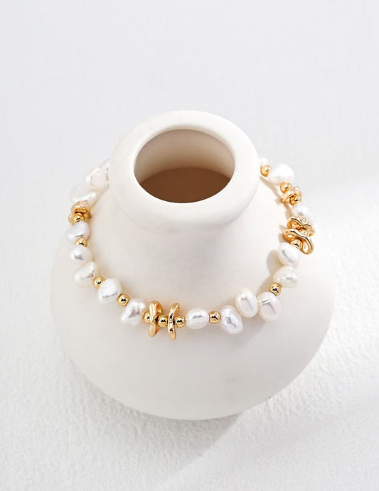 Zoom sur le bracelet Lianes d’Or exposé autour d’une tasse blanche, détails des perles et maillons