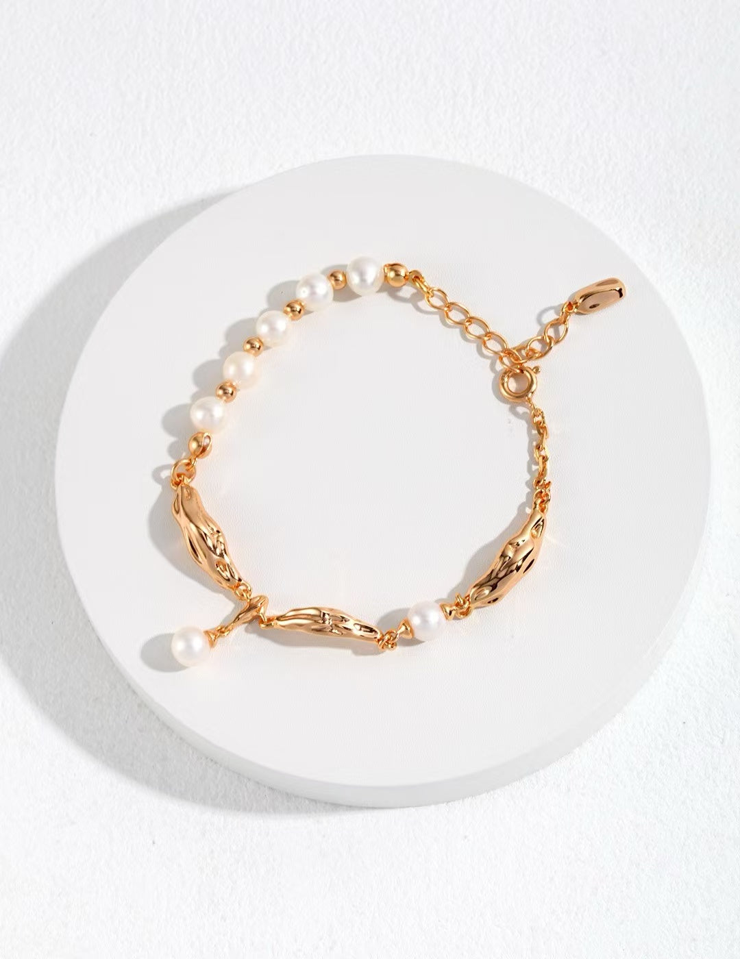 Bracelet doré 925 avec perles naturelles blanches sur fond blanc