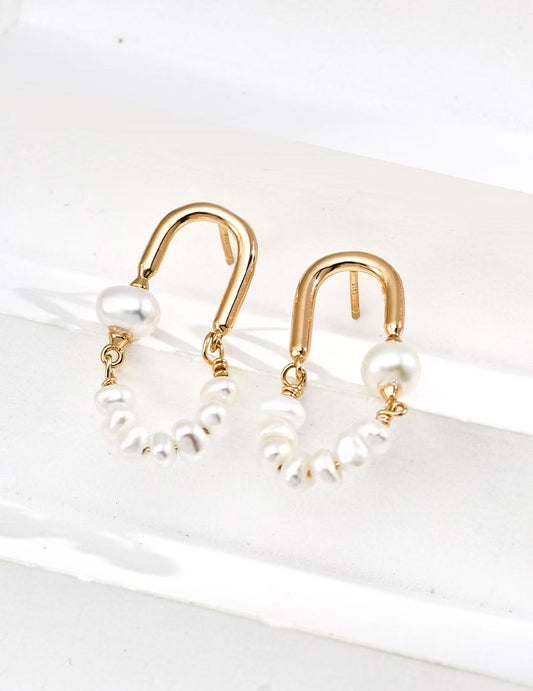 Zoom sur les boucles créoles dorées avec perles naturelles