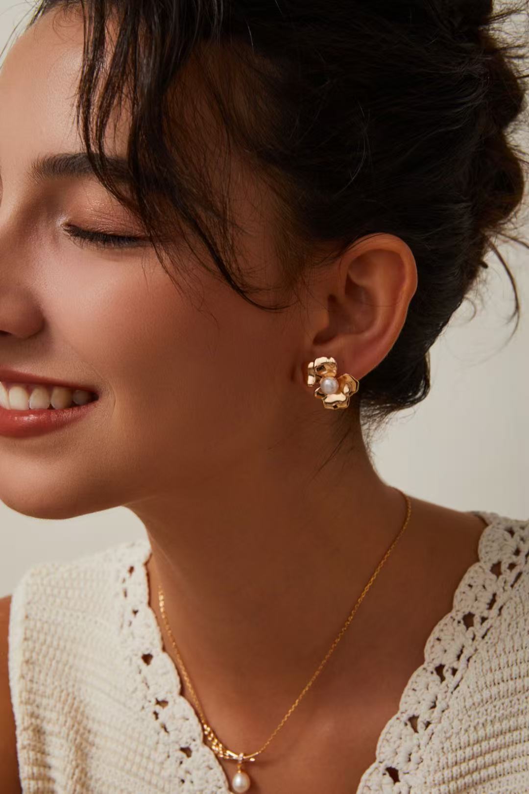  Boucles d’oreilles dorées en forme de fleur avec perle, portées avec collier