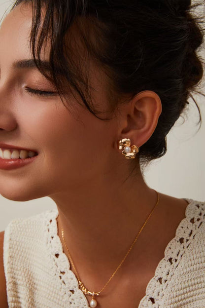  Boucles d’oreilles dorées en forme de fleur avec perle, portées avec collier