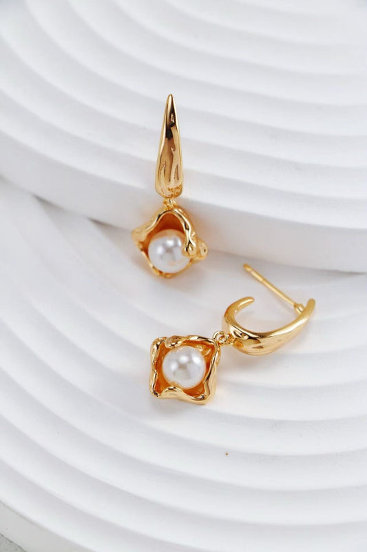 Gros plan sur une paire de boucles d’oreilles dorées avec perles nacrées naturelles – MeiPerle