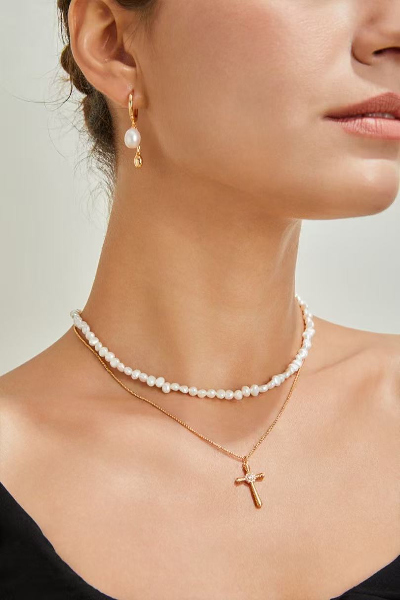 Femme portant les boucles d’oreilles en perles naturelles dorées – Larmes de Perle par MeiPerle

