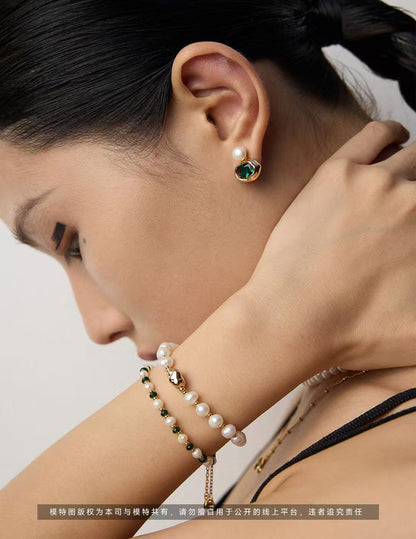 Superposition de bracelets en perles naturelles blanches et vertes au poignet – style chic et moderne