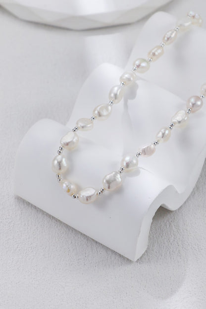 Collier perles baroques exposé sur présentoir blanc
