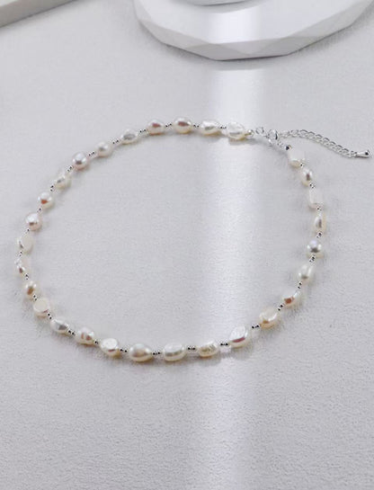 Collier de perles baroques avec fermoir mousqueton argenté sur fond gris