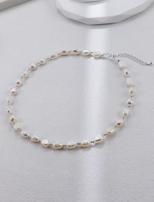 Collier de perles baroques avec fermoir mousqueton argenté sur fond gris