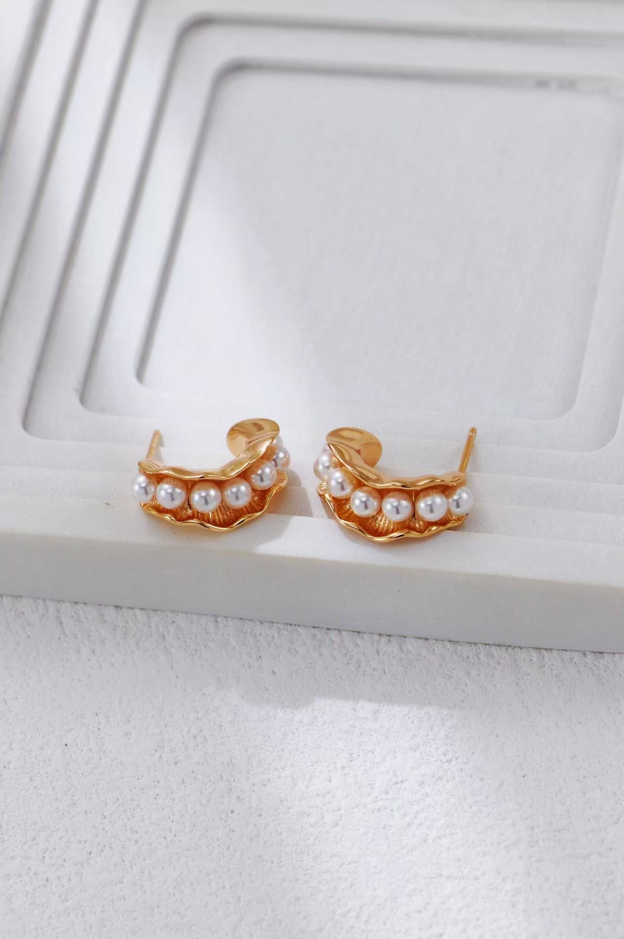 Zoom sur les détails des boucles d’oreilles Vagues d’Or en dorure S925 et perles blanches