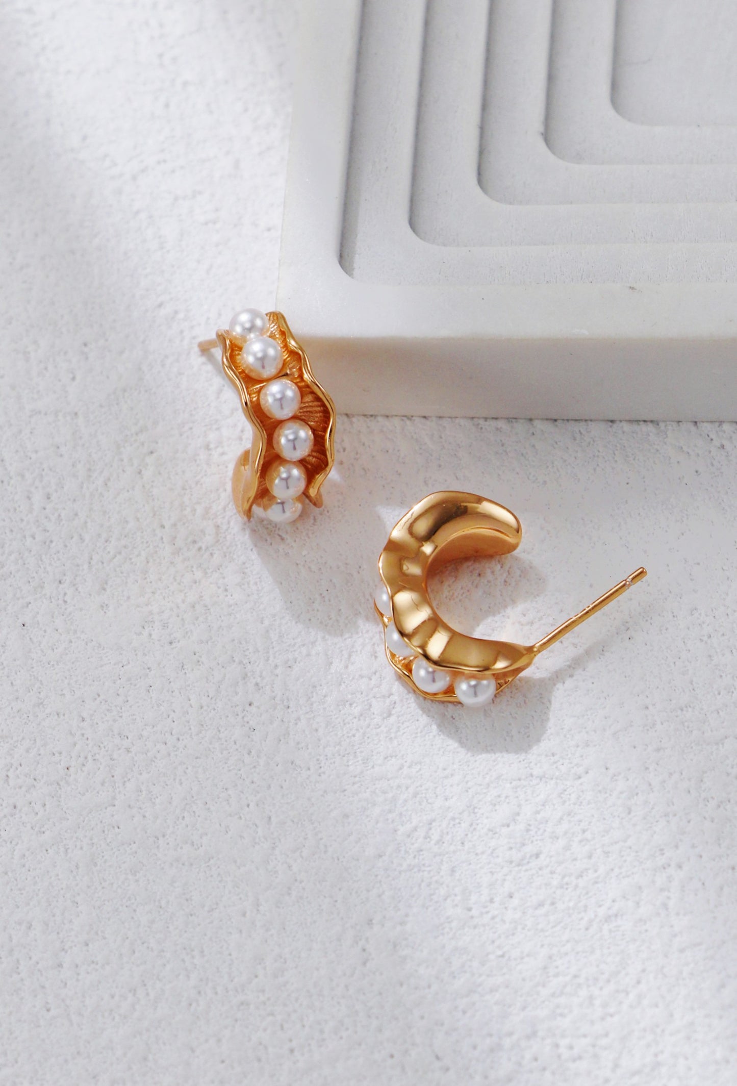 Boucles d’oreilles Vagues d’Or en perles naturelles et dorure S925 posées à plat sur fond clair